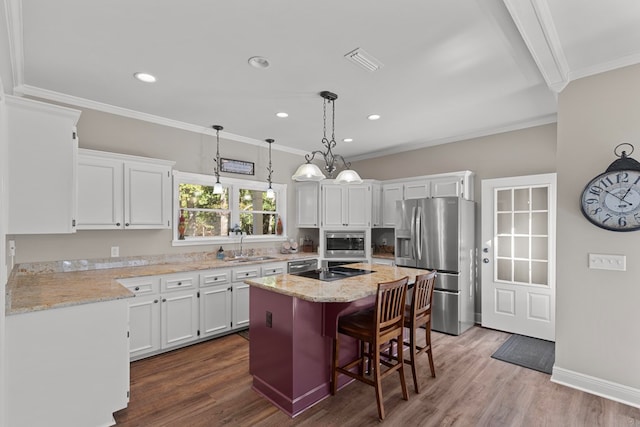 kitchen featuring a breakfast bar area, white cabinetry, ornamental molding, a kitchen island, and stainless steel appliances