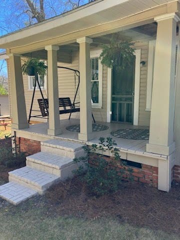 view of exterior entry featuring covered porch