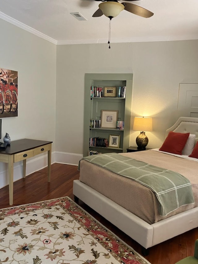 bedroom featuring crown molding, visible vents, ceiling fan, wood finished floors, and baseboards