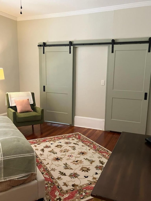 living room featuring a barn door, ornamental molding, and dark wood-type flooring