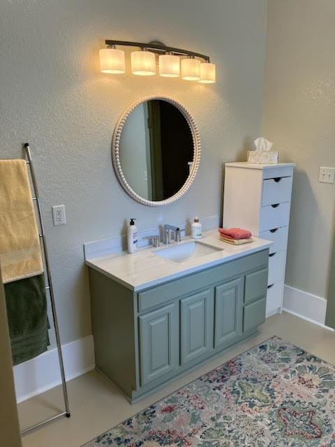 bathroom with a textured wall and vanity