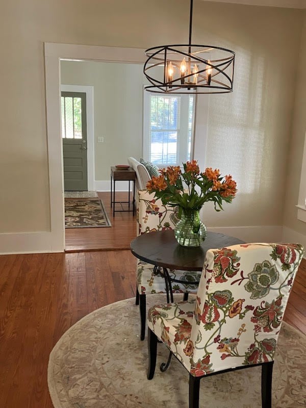 dining area featuring wood-type flooring, baseboards, and an inviting chandelier