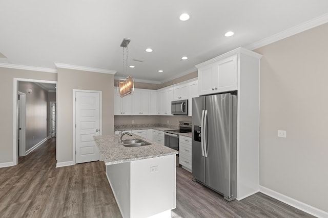 kitchen with appliances with stainless steel finishes, a kitchen island with sink, dark wood-type flooring, sink, and pendant lighting