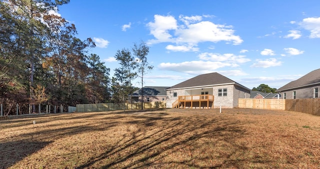 back of property with a deck and a yard