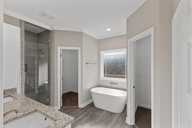 bathroom featuring hardwood / wood-style floors, vanity, shower with separate bathtub, and ornamental molding