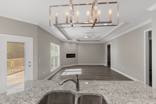 kitchen featuring light stone countertops, sink, dark hardwood / wood-style flooring, pendant lighting, and ceiling fan with notable chandelier