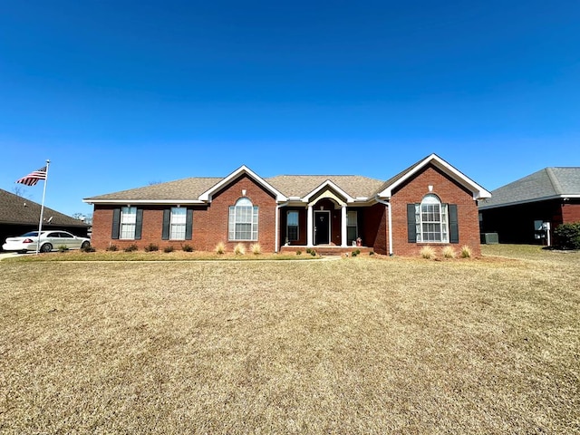 ranch-style house featuring brick siding and a front yard