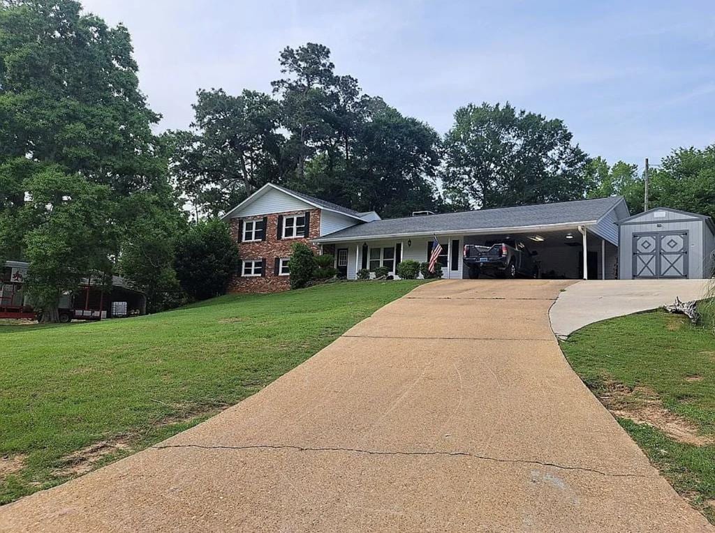 203 Pine Forest Cir, Troy, AL 36010 - tri-level home with concrete driveway, a front yard, a carport, and brick siding