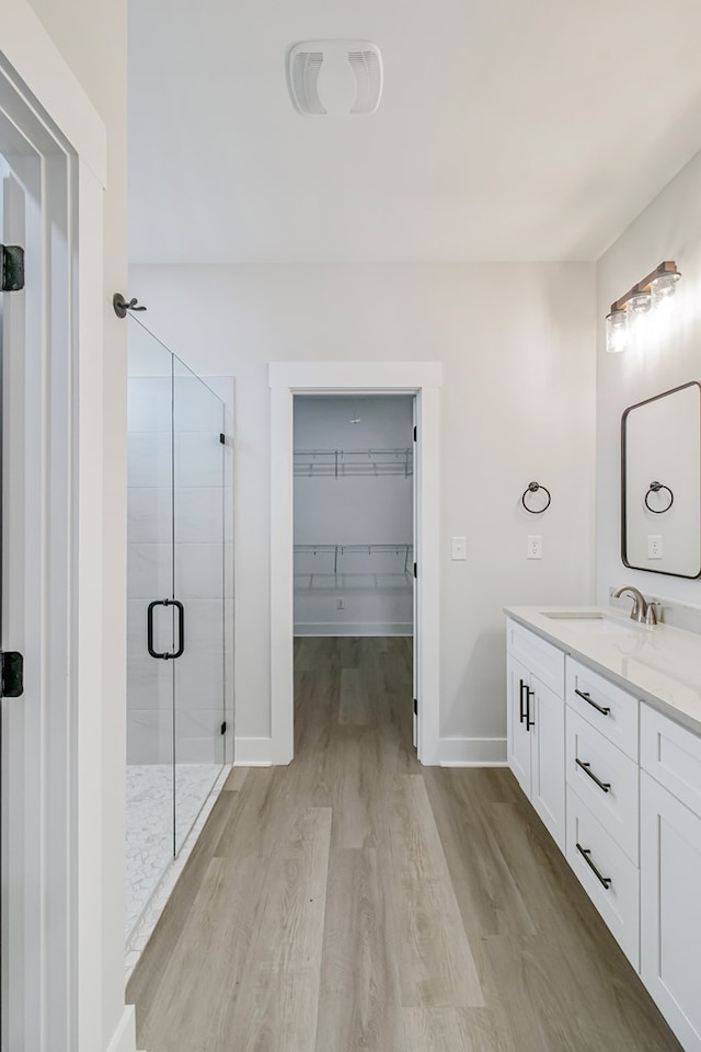1919 Silcox Rd, Ashford, AL 36312 - full bath featuring vanity, a walk in closet, baseboards, a shower stall, and wood finished floors