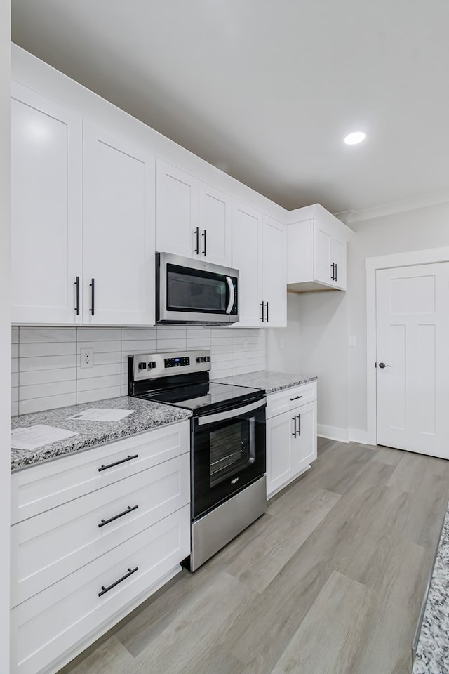 1919 Silcox Rd, Ashford, AL 36312 - kitchen featuring light wood finished floors, light stone countertops, decorative backsplash, and appliances with stainless steel finishes