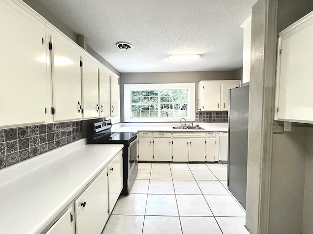 115 Westmont Dr, Dothan, AL 36301 - kitchen featuring stainless steel appliances, decorative backsplash, white cabinets, light tile patterned flooring, and light countertops