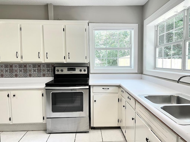 115 Westmont Dr, Dothan, AL 36301 - kitchen featuring electric stove, light tile patterned floors, light countertops, and white cabinets