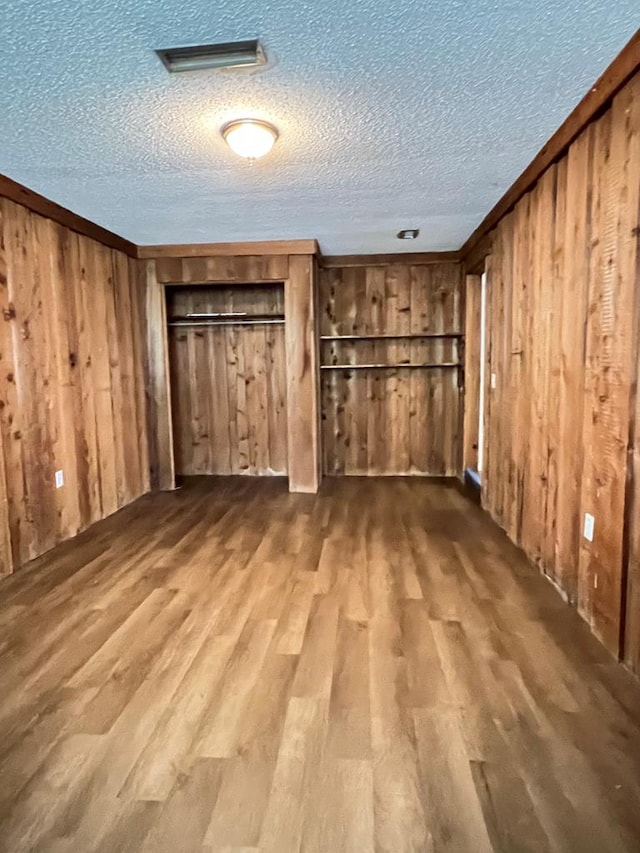 115 Westmont Dr, Dothan, AL 36301 - unfurnished bedroom featuring wood finished floors, wooden walls, a textured ceiling, and a closet