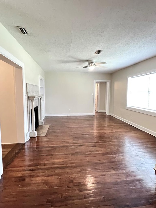 115 Westmont Dr, Dothan, AL 36301 - unfurnished living room featuring a textured ceiling, dark wood finished floors, a ceiling fan, and a fireplace