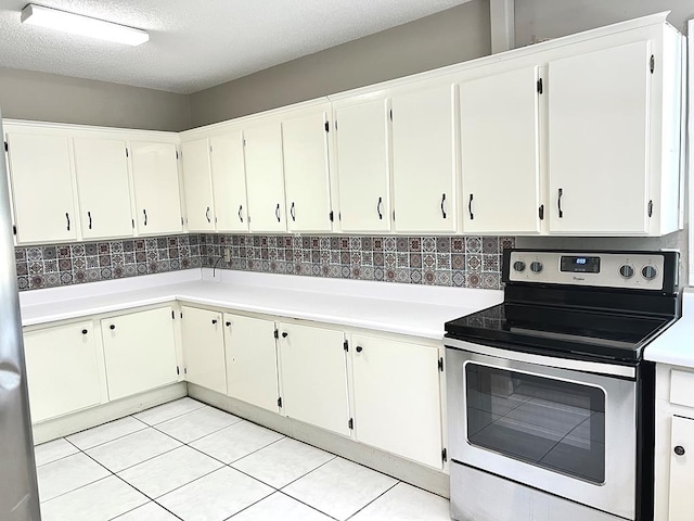 115 Westmont Dr, Dothan, AL 36301 - kitchen featuring stainless steel range with electric stovetop, light countertops, tasteful backsplash, light tile patterned flooring, and a textured ceiling