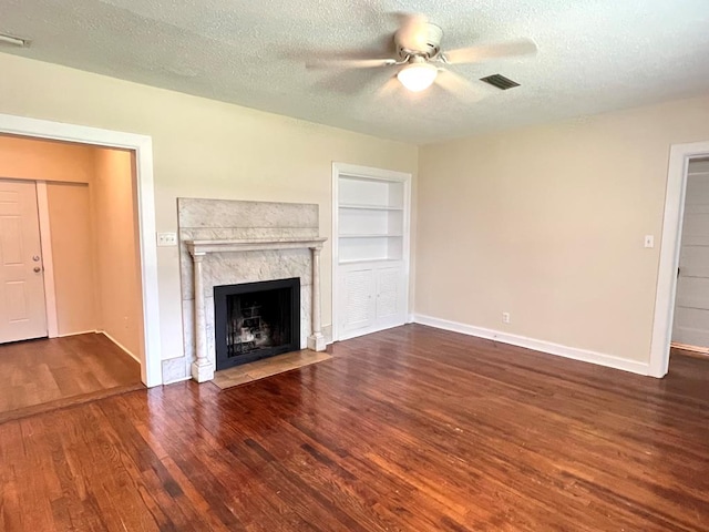 115 Westmont Dr, Dothan, AL 36301 - unfurnished living room featuring ceiling fan, wood finished floors, a high end fireplace, a textured ceiling, and built in shelves