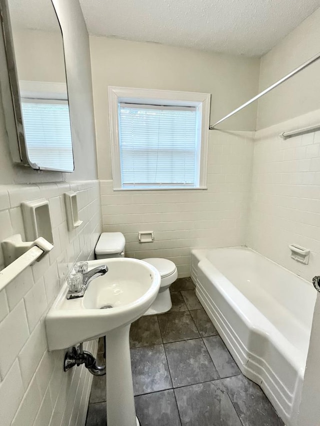 115 Westmont Dr, Dothan, AL 36301 - bathroom with tile walls, tile patterned flooring, bathtub / shower combination, a textured ceiling, and wainscoting