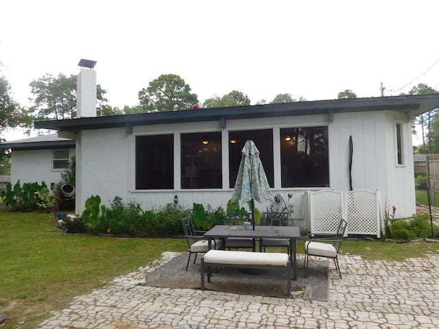207 Seeba Dr, Dothan, AL 36303 - rear view of house featuring a patio, a chimney, outdoor dining area, and a yard