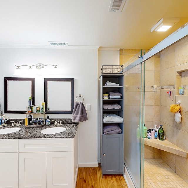207 Seeba Dr, Dothan, AL 36303 - bathroom featuring double vanity, a shower stall, wood finished floors, and crown molding