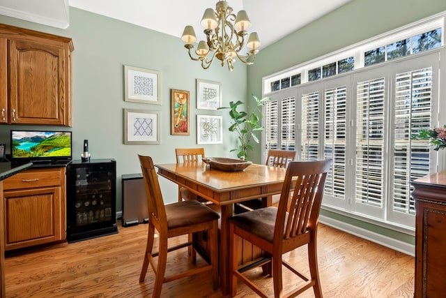 dining room featuring wine cooler, light wood-style flooring, and a notable chandelier