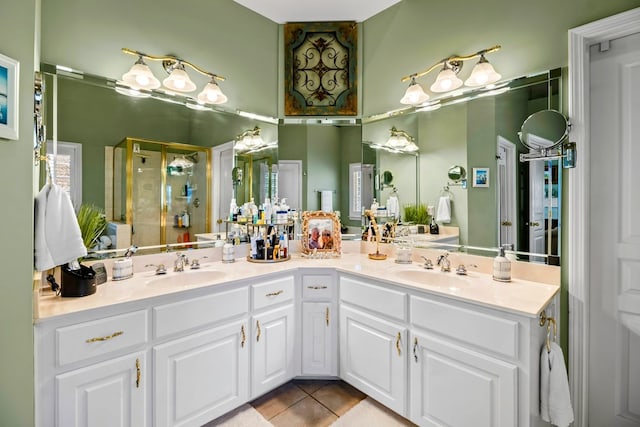 bathroom with tile patterned flooring, a sink, a shower stall, and double vanity