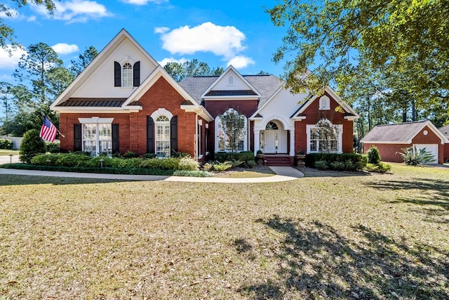 view of front of property featuring brick siding, an outdoor structure, and a front lawn