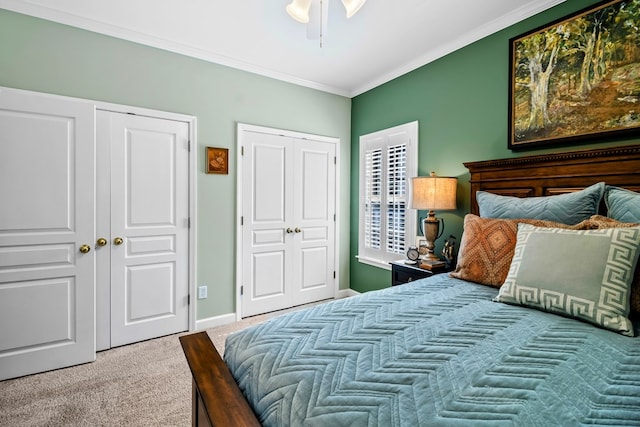 bedroom featuring multiple closets, baseboards, crown molding, and carpet flooring