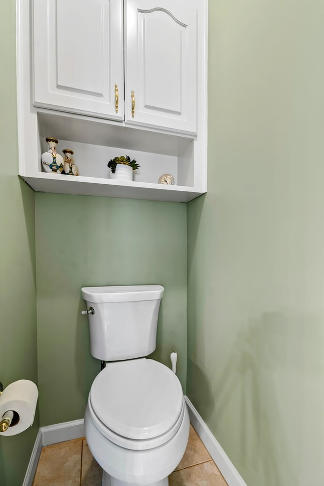 bathroom featuring toilet, baseboards, and tile patterned floors