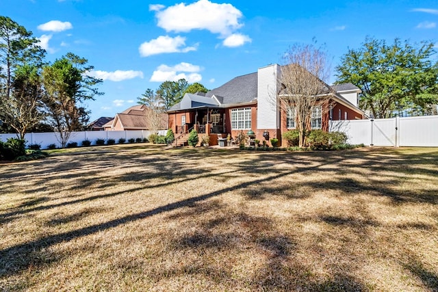 view of front of house featuring a front yard, a gate, and a fenced backyard