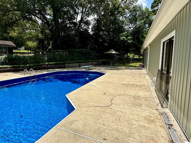 426 Walker Rd, Ozark, AL 36360 - view of swimming pool with a patio, a fenced backyard, a diving board, and view of wooded area