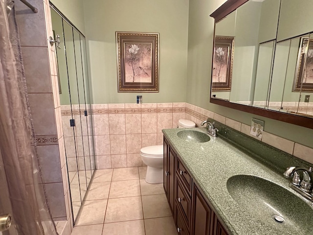 426 Walker Rd, Ozark, AL 36360 - bathroom with a stall shower, double vanity, tile patterned floors, wainscoting, and tile walls