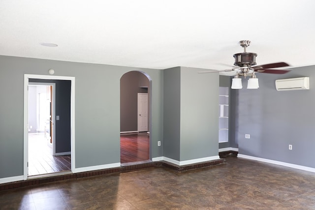 40 Caravan Ln, Kinsey, AL 36303 - empty room with an AC wall unit, arched walkways, a ceiling fan, and baseboards