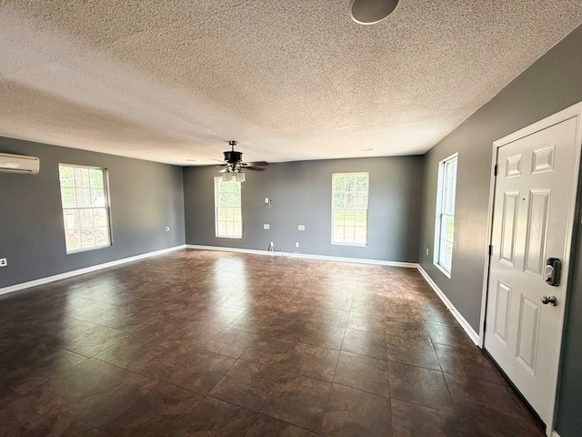 40 Caravan Ln, Kinsey, AL 36303 - spare room featuring healthy amount of natural light, a textured ceiling, a wall mounted air conditioner, a ceiling fan, and baseboards