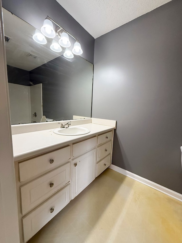 40 Caravan Ln, Kinsey, AL 36303 - full bathroom with vanity, baseboards, a shower, a textured ceiling, and tile patterned floors
