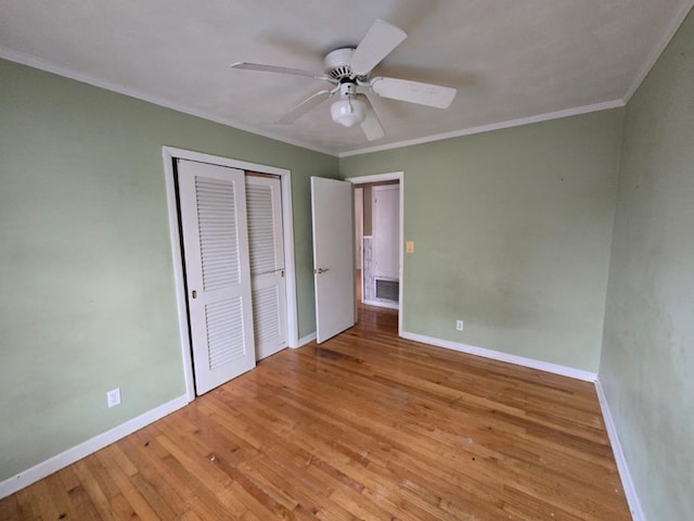 unfurnished bedroom with crown molding, a closet, ceiling fan, and light wood-type flooring