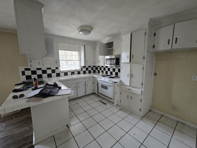 kitchen with tasteful backsplash, sink, white cabinets, white electric range oven, and kitchen peninsula