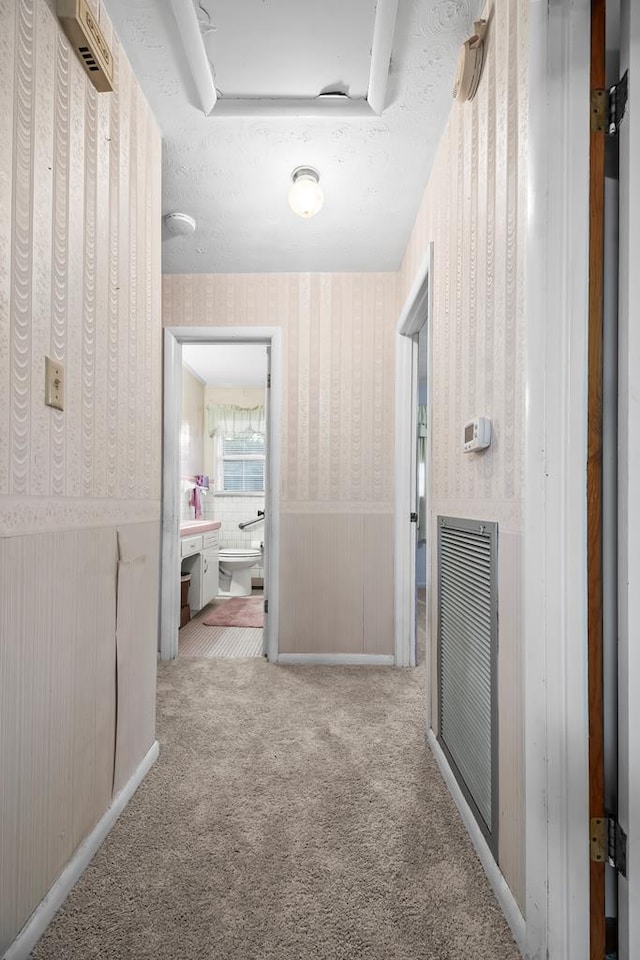 902 Moss St, Dothan, AL 36301 - hallway featuring wallpapered walls, carpet, and wainscoting