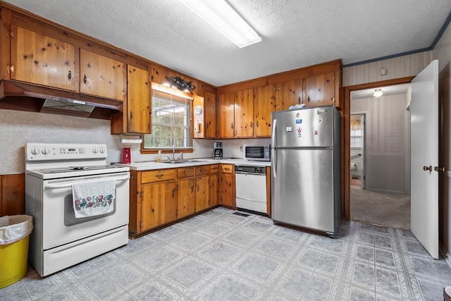 902 Moss St, Dothan, AL 36301 - kitchen with stainless steel appliances, under cabinet range hood, a sink, light countertops, and brown cabinets