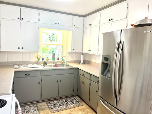 449 County Road 112, Columbia, AL 36319 - kitchen with stainless steel fridge with ice dispenser, range, a sink, light countertops, and white cabinetry
