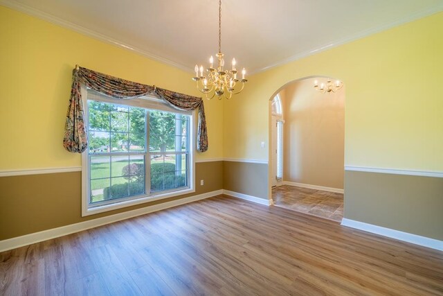 401 Dunleith Blvd, Dothan, AL 36303 - unfurnished room with a chandelier, arched walkways, wood finished floors, and crown molding