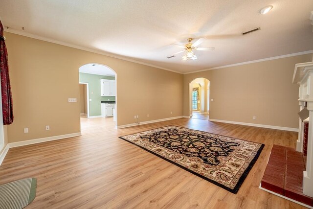 401 Dunleith Blvd, Dothan, AL 36303 - unfurnished living room featuring arched walkways, ceiling fan, light wood finished floors, ornamental molding, and baseboards