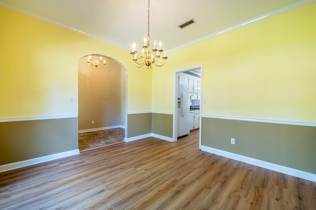 401 Dunleith Blvd, Dothan, AL 36303 - unfurnished room with a chandelier, arched walkways, crown molding, wood finished floors, and baseboards