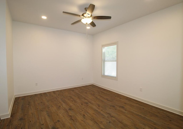 spare room with dark hardwood / wood-style flooring and ceiling fan