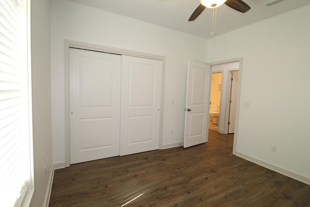 unfurnished bedroom featuring a closet, ceiling fan, and dark wood-type flooring