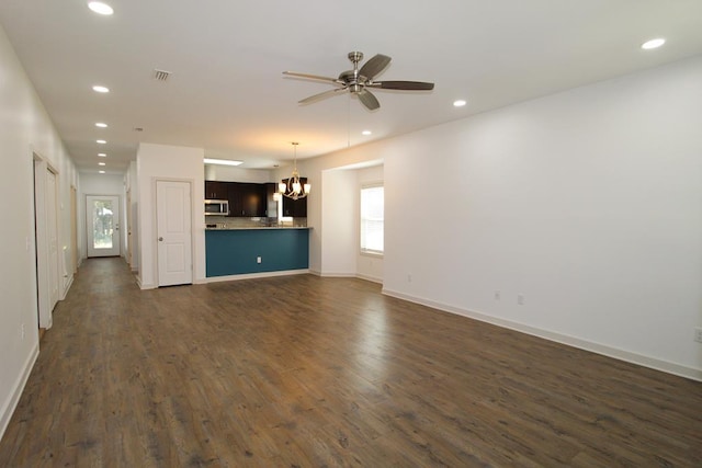 unfurnished living room featuring ceiling fan with notable chandelier and dark wood-type flooring