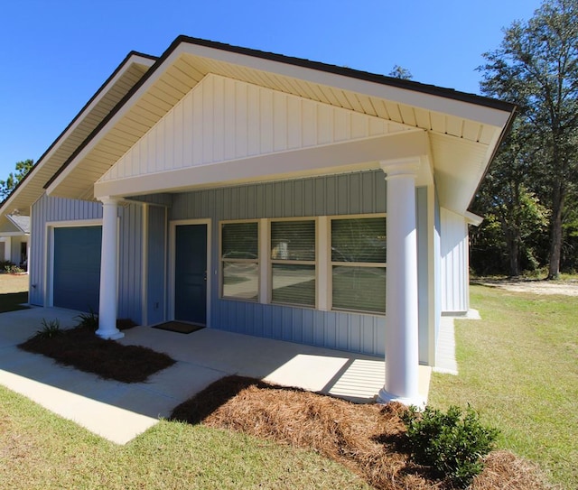 view of front of home featuring a porch, a garage, and a front lawn