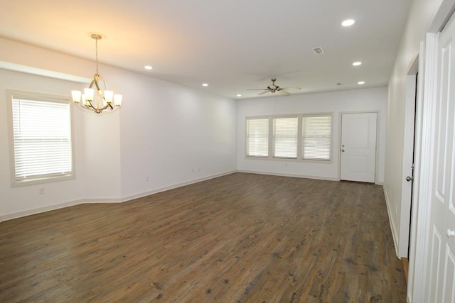 empty room featuring ceiling fan with notable chandelier and dark hardwood / wood-style floors