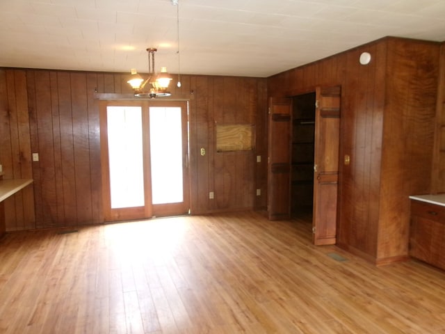 934 Sunset Blvd, Elba, AL 36323 - unfurnished dining area with wooden walls, light wood finished floors, and a chandelier