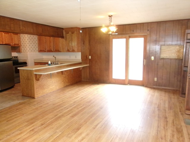 934 Sunset Blvd, Elba, AL 36323 - kitchen with appliances with stainless steel finishes, brown cabinetry, light countertops, a peninsula, and light wood-style flooring
