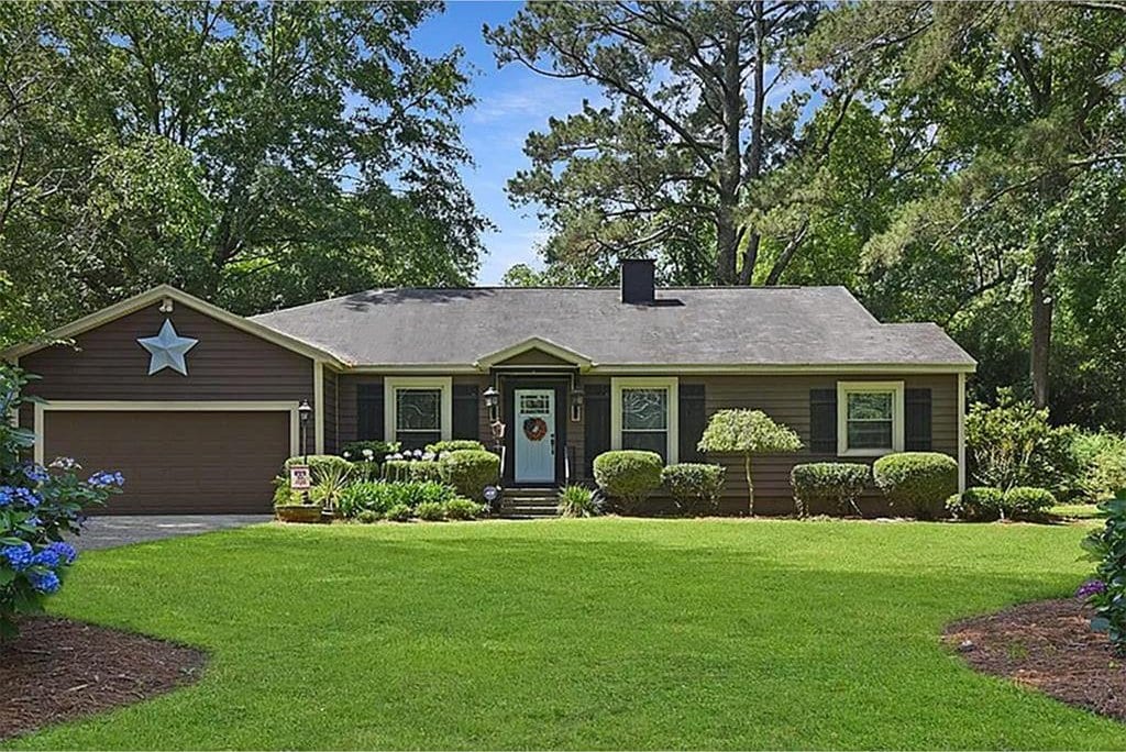 single story home with a front yard and a garage